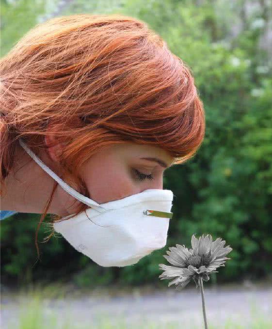 Wąchanie kwiatka przez maskę