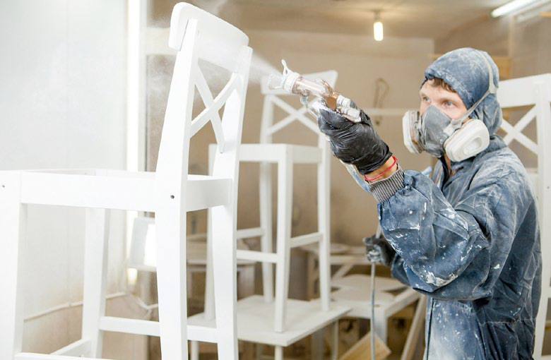 Mężczyzna opryskujący krzesła chemikaliami