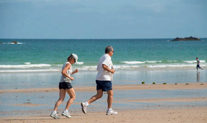 Starsza para biegająca po plaży