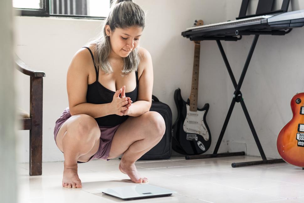 kobieta patrząca na wagę