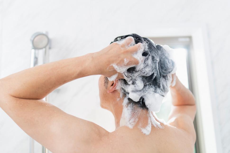 mężczyzna myjący włosy